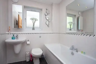 a white bathroom with a toilet and a sink at Southside Flat with Private Garden! in Glasgow