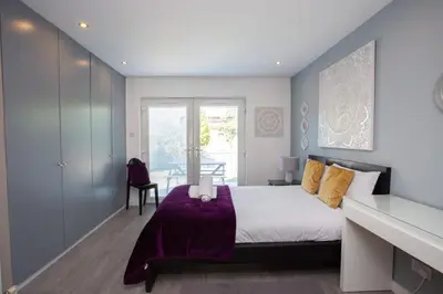 a bedroom with a bed with a purple blanket at Southside Flat with Private Garden! in Glasgow