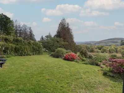 a park with a bench in the middle of a field at Innishail in Lochgilphead