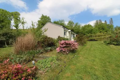 a house in the middle of a yard with flowers at Innishail in Lochgilphead