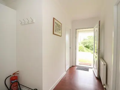 an empty hallway with a door leading to a window at Innishail in Lochgilphead