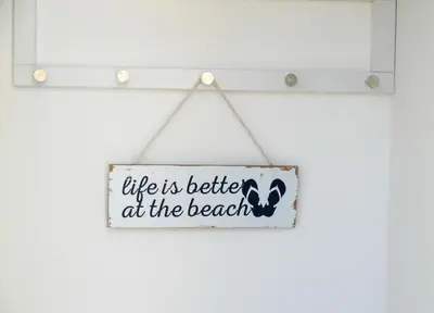 a sign that says life is better at the beach at No 8 Westbay Apartment in Oban