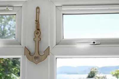 a window with a cross hanging on a wall at No 8 Westbay Apartment in Oban
