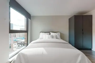 a white bed in a room with a large window at Canvas Glasgow in Glasgow