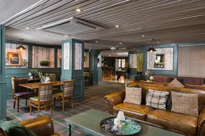 a lobby with leather furniture and a dining room at The Kirkhouse Inn in Strathblane