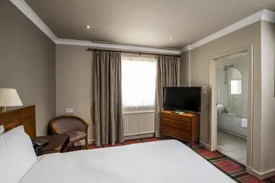 a hotel room with a bed and a television at The Kirkhouse Inn in Strathblane