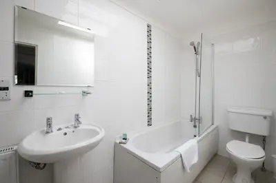a white bathroom with a sink and a toilet at The Kirkhouse Inn in Strathblane