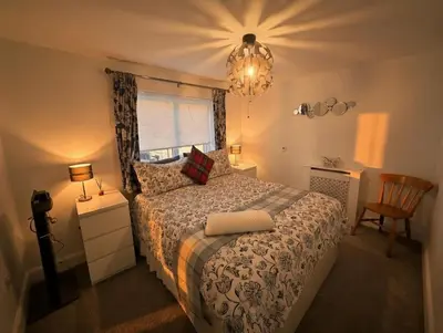 a bedroom with a bed and a window and a chandelier at Dreghorn House 5 b-rooms 9 beds 3 toilets 2 showers,1 bath 2 receiption Secure free Parking 233 Wifi in Edinburgh