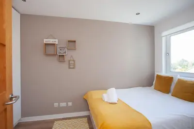 a small bedroom with a bed and a window at Mosspark Boulevard Exec Apartment ii - Free Parking in Glasgow