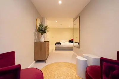 a living room with a bed and a mirror at Argyl - Central Old Town Mews Home with Parking in Edinburgh
