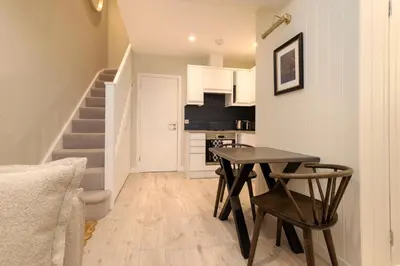 a small dining room with a table and a kitchen at Argyl - Central Old Town Mews Home with Parking in Edinburgh