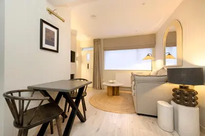 a living room with a bed and a table at Argyl - Central Old Town Mews Home with Parking in Edinburgh