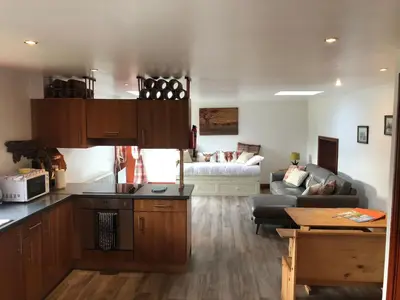 a kitchen and a living room with a couch at Maberry Cottage in Bargrennan