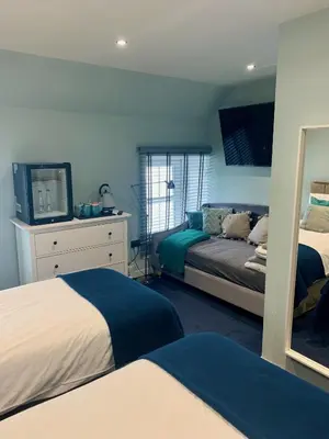 a bedroom with two beds and a television in it at Lochindaal Hotel in Port Charlotte