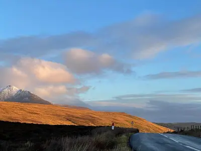 a road on the side of a hill with a mountain at Arran School House - Blackwaterfoot, Isle of Arran in Blackwaterfoot