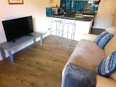 a living room with a couch and a table with a tv at Fabulous location, One Bedroom West End Flat, just off Byres rd, close to SEC & Hydro in Glasgow