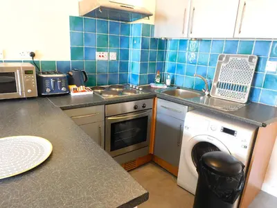 a kitchen with a washing machine and a dishwasher at Fabulous location, One Bedroom West End Flat, just off Byres rd, close to SEC & Hydro in Glasgow