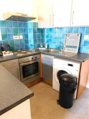 a kitchen with a stove and a sink and a dishwasher at Fabulous location, One Bedroom West End Flat, just off Byres rd, close to SEC & Hydro in Glasgow
