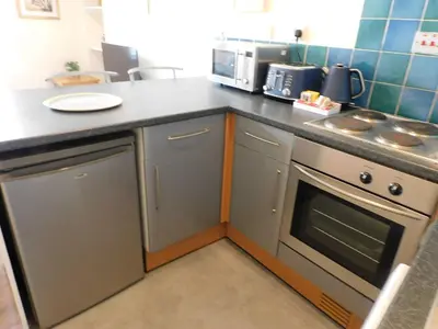 a kitchen with a counter top with a stove top oven at Fabulous location, One Bedroom West End Flat, just off Byres rd, close to SEC & Hydro in Glasgow