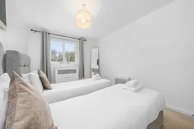 two white beds in a room with a window at Saughton Suite with views of Water of Leith in Edinburgh