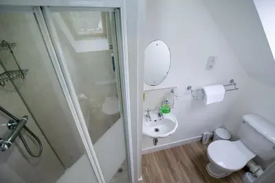 a bathroom with a shower and a toilet and a sink at Corran Bunkhouse in Onich