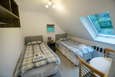 two beds in a small room with a window at Corran Bunkhouse in Onich