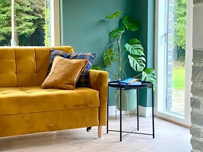 a yellow couch in a living room with a plant at The Lodge at Muir Estate in Thornhill