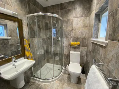 a bathroom with a shower and a toilet and a sink at The Lodge at Muir Estate in Thornhill