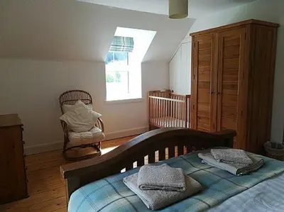 a bedroom with a bed and a dresser and a window at Keeper's Cottage in Lochgilphead