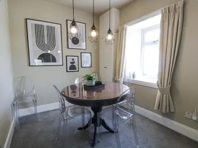 a dining room with a table and chairs and a window at Ailsa Shores in Turnberry