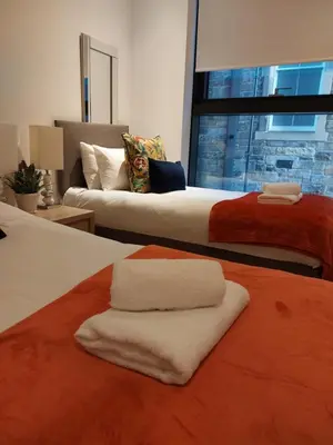 a bedroom with two beds with towels on them at Quartermile Luxury Landing Apartment in Edinburgh
