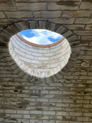 a circular window in a brick building with the sky at Pirnie Lodge Holiday Lets in Slamannan