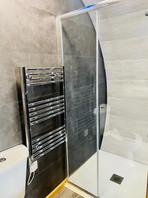 a shower with a glass door in a bathroom at Pirnie Lodge Holiday Lets in Slamannan