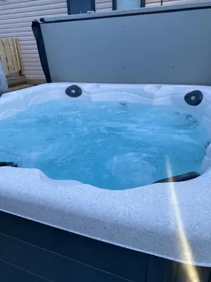a bath tub with blue water in it at Pirnie Lodge Holiday Lets in Slamannan