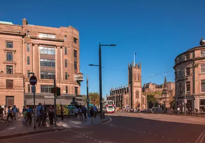 a group of people crossing a street in a city at Shandwick Apartment - Edinburgh City Centre - Sleeps 2 in Edinburgh