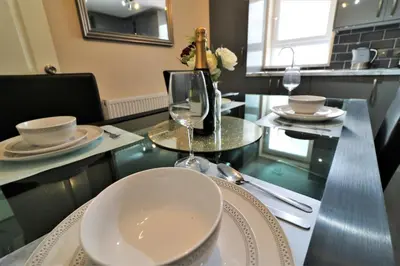 a dining table with a wine glass on top of it at Signature - Kirkhill Lower in Kirkmuirhill