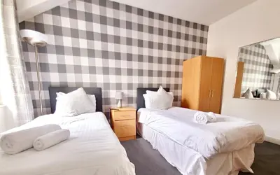 a bedroom with two beds with white sheets at Aberfoyle Inn in Aberfoyle