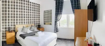a bedroom with a white bed and a window and a tub at Aberfoyle Inn in Aberfoyle