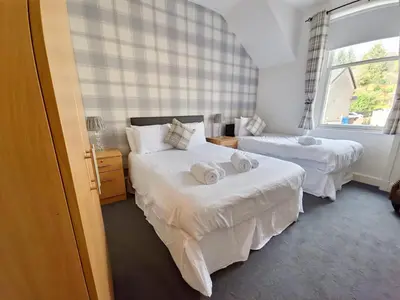 a bedroom with two beds and a window at Aberfoyle Inn in Aberfoyle