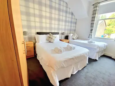 a hotel room with two beds and a window at Aberfoyle Inn in Aberfoyle