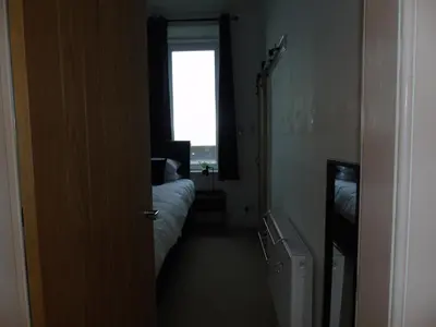a room with a bedroom with a bed and a window at Snug - Sealladh Mara Apartment in Helensburgh