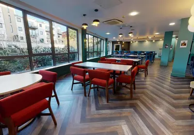 a restaurant with tables and chairs and windows at iQ Grove Accomodation in Edinburgh in Edinburgh