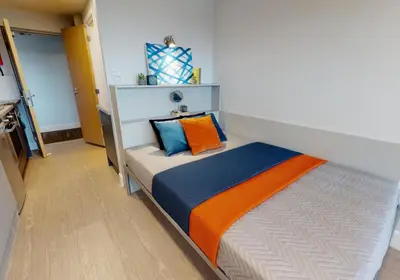 a bedroom with a bed with orange and blue pillows at iQ Grove Accomodation in Edinburgh in Edinburgh