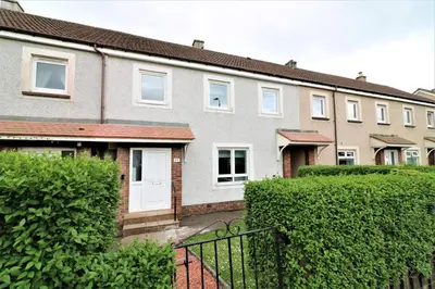 a row of houses with bushes in front of them at Signature - Caldercruix House in Caldercruix