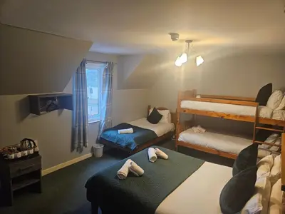 a bedroom with two bunk beds with towels on them at Tailrace Inn in Kinlochleven