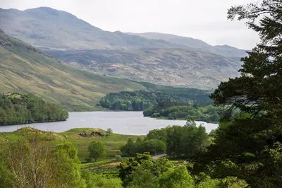 a view of a lake in a valley with mountains at Capercaillie Cottage in Crianlarich