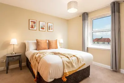 a bedroom with a large bed and a window at Old Prestwick View - Donnini Apartments in Prestwick