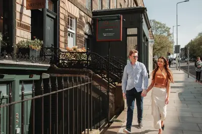 a man and a woman walking down a street at No1 Apartments Edinburgh - New Town in Edinburgh