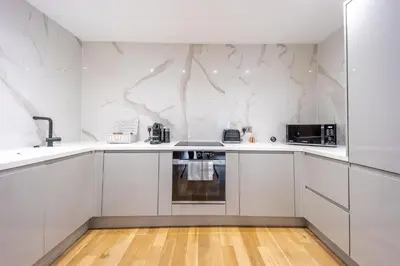 a white kitchen with white counters and appliances at No1 Apartments Edinburgh - New Town in Edinburgh