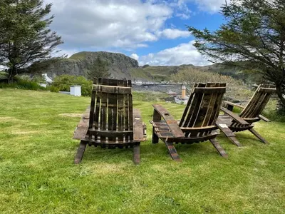 a group of three chairs sitting in the grass at Easdale Cottage in Oban